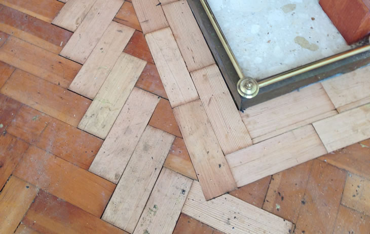 A herringbone parquet floor during restoration